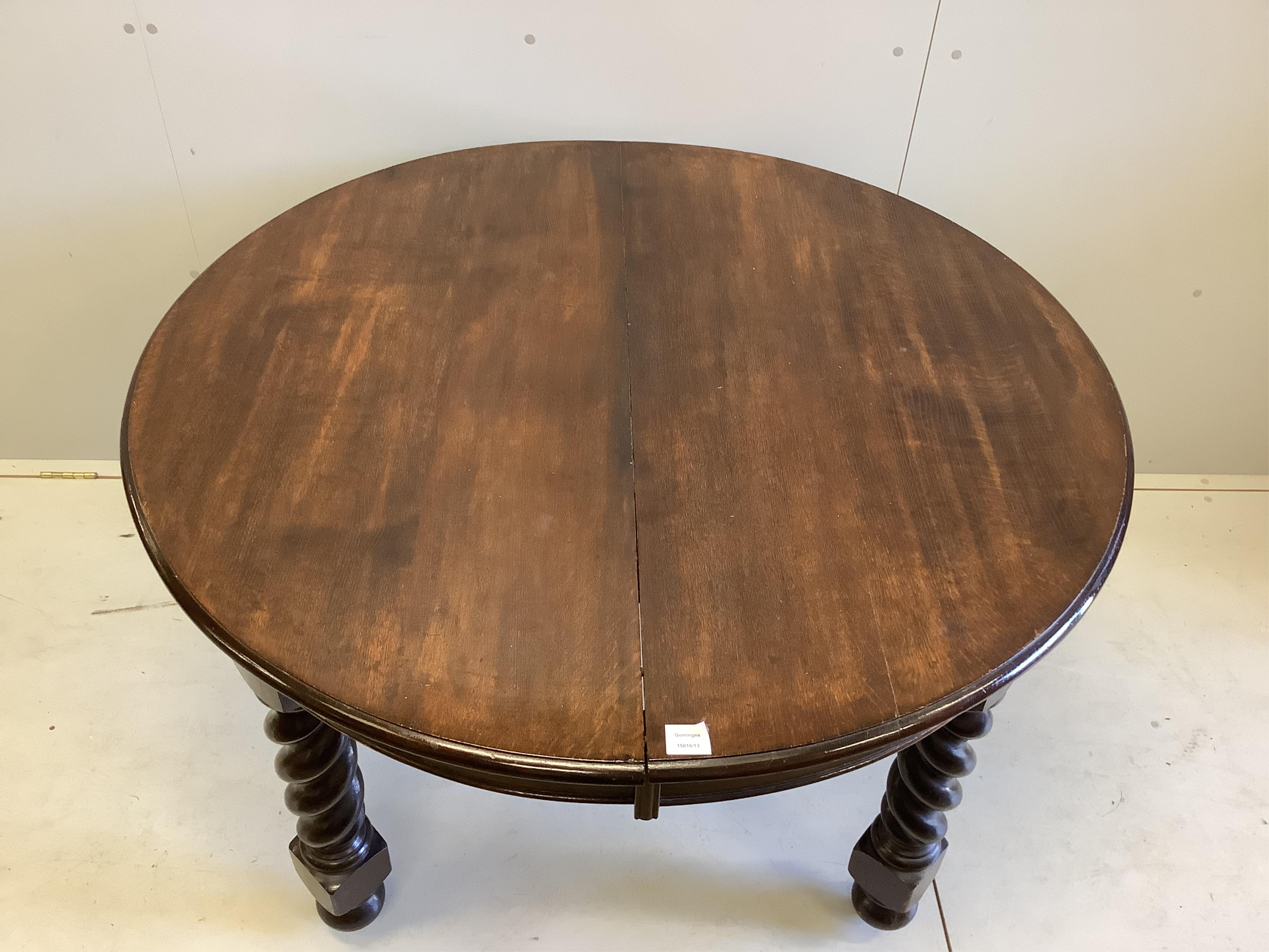 A 1920's oak 'D' end extending dining table, 234cm extended, two spare leaves, depth 120cm, height 74cm. Condition - fair